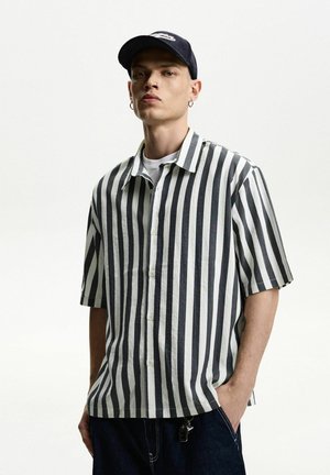 Short-sleeved button-up shirt in black and white vertical stripes, with a relaxed fit and a smooth, lightweight fabric.