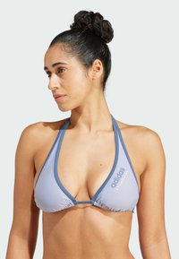 Ljusblå triangulär bikinitäckning med rynkat mönster, kontrasterande kanter och en "adidas"-logotyp tryckt i blått. Slät tygtextur.