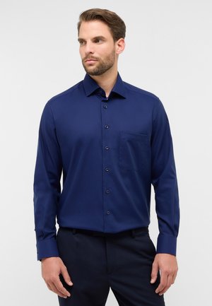 Langærmet skjorte i mørk marineblå, lavet af glat stof, med knaplukning fortil, lomme og justerbare manchetter.