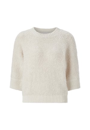 Lichtbeige trui met een zachte, fluffy textuur, en geribde halslijn en manchetten. Heeft een losse pasvorm en korte mouwen.