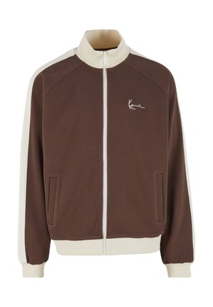 Braune Jacke mit Reißverschluss in Cremeakzenten, geripptem Kragen und elastischen Bündchen. Verfügt über seitliche Taschen und ein gesticktes Logo auf der Brust.