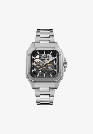 Vierkante roestvrijstalen horloge met een zwart skeleton-dial, automatische beweging en een zilveren metalen band met geborstelde en gepolijste schakels.