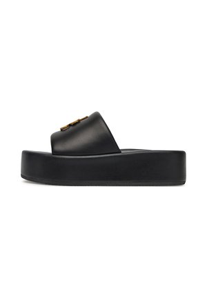 Sandale negre din piele, cu talpă groasă texturată, având un accent de aur pe brâu și un design minimalist.