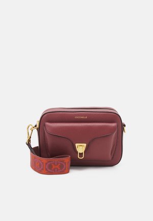 Bordeauxrode leren crossbodytas met voorvak, sluiting in goudkleur en afneembare rood-oranje stoffen band met patroon.