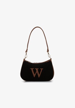 Černá kabelka z umělé kožešiny s hnědým koženým popruhem a zipem, s výrazným hnědým logem 'W' na přední straně. Kulatý, strukturovaný tvar.