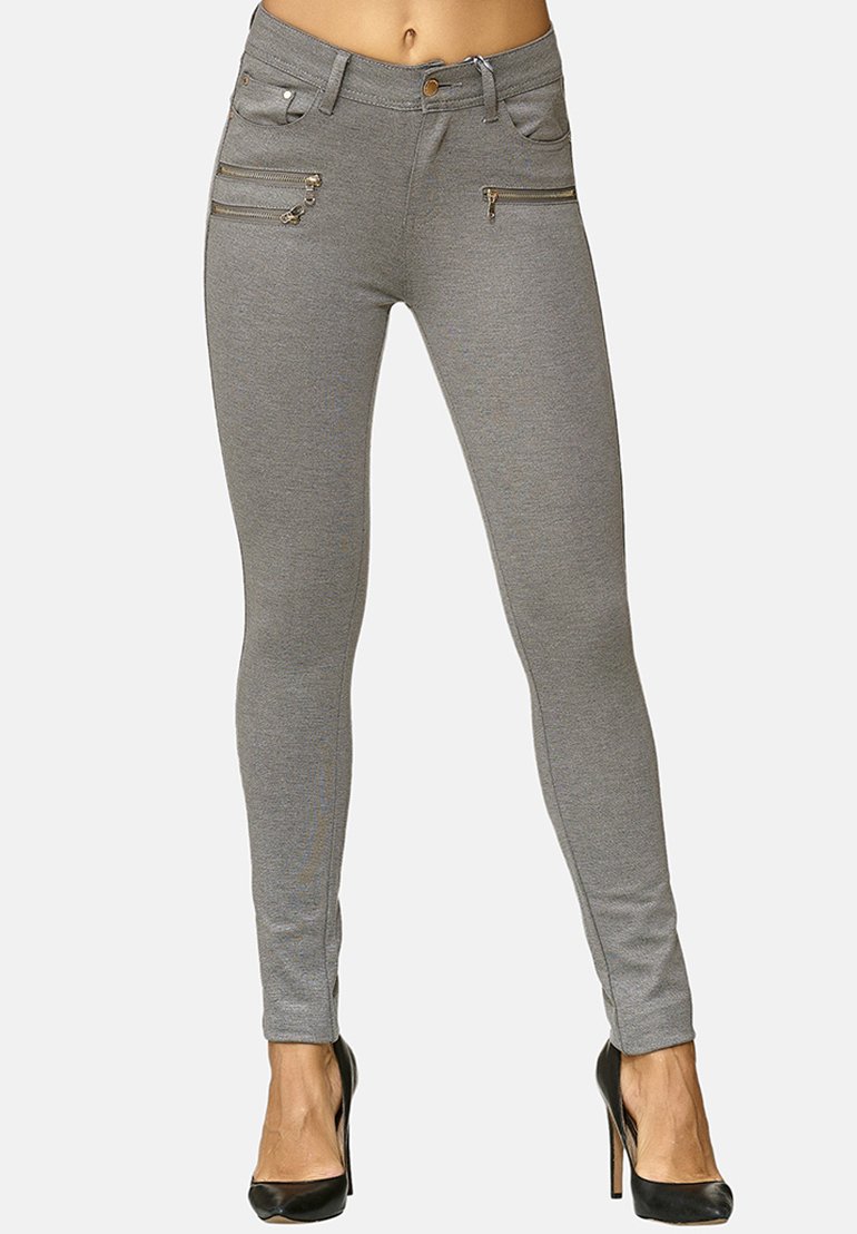 Jeans skinny grigi con tasche con cerniera, design elegante e texture liscia. Abbinati a tacchi neri alti per un look moderno.
