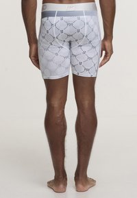 White boxer briefs featuring a geometric pattern with numbers. Made of stretchy fabric, with a soft elastic waistband for comfort.