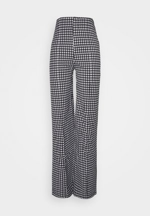 Pantalon large taille haute avec motif pied-de-poule noir et blanc, présenté sur un fond uni clair.