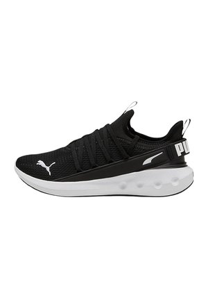 Zapatilla deportiva negra con parte superior de malla, cordones elásticos y una media suela blanca. Presenta un talón reforzado con la marca "PUMA".