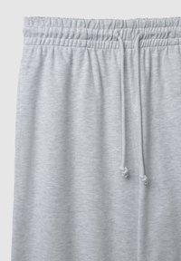 Helle graue Jogginghose mit einem gerippten, elastischen Bund, Kordelzugverschluss und weichem, strukturiertem Stoff mit glatter Oberfläche.