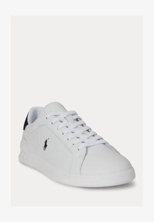 Scarpa da ginnastica bianca a taglio basso con lacci bianchi, logo Polo Ralph Lauren nero sul lato e puntale posteriore nero, angolata per mostrare la parte anteriore e il lato esterno.