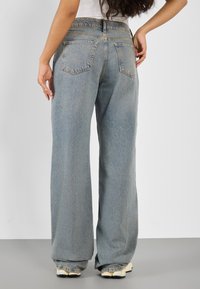 Ljust blå vida jeans i denim, med hög midja, femfickorsdesign och subtilt blekt mönster.