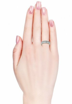 Anello d'argento con numerosi piccoli diamanti trasparenti su una mano sottile e liscia. Le unghie sono dipinte di rosa pallido, esaltando la brillantezza dell'anello.