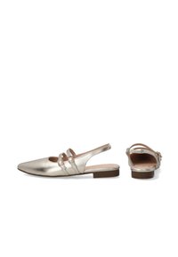 Metalen gouden slingback ballerina's met een spitse neus, twee bandaccenten met cirkelvormige hardware, vlakke hak en een gladde leren textuur.