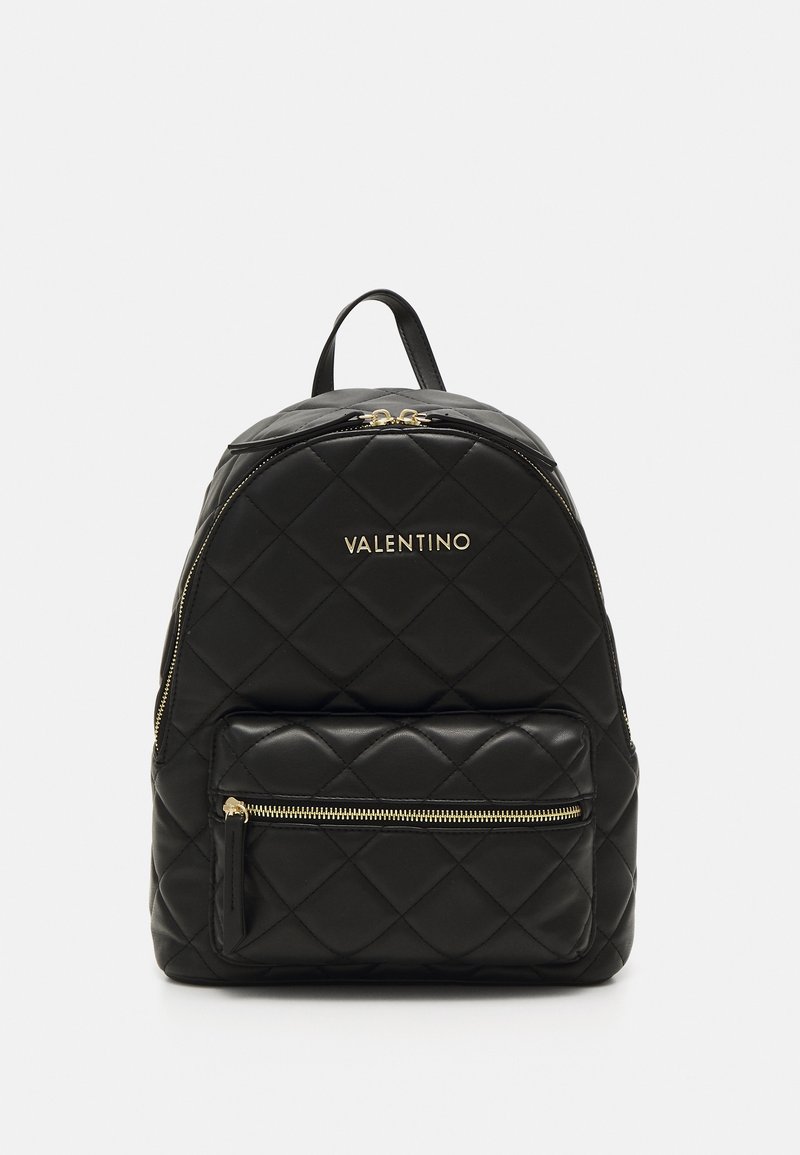 Black quilted leather backpack with gold hardware. Features a front zip pocket and adjustable straps. Logo text displayed on the front.