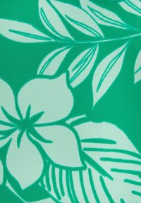 Tessuto verde con un motivo floreale caratterizzato da foglie e fiori verde chiaro, superficie testurizzata e finitura liscia.