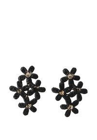Pendientes en forma de flor de color negro con pétalos texturados, adornados con pequeños acentos dorados. Elaborados con material flexible y tejido.
