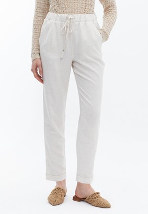 Lichtbeige linnen broek met een elastische tailleband en trekkoord, voorzien van zijzakken en omslagennen, gecombineerd met geweven instap schoenen.