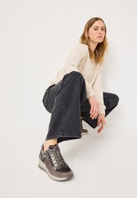 Grå och bruna sneakers i en blandning av mocka och textilmaterial, med en kilklacksål och sidodetalj med dragkedja.