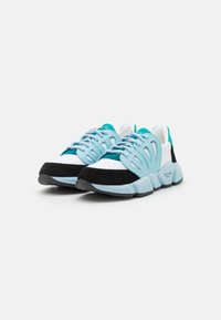 Scarpe da ginnastica turchesi e nere con tomaia in rete, sistema di allacciatura regolabile e suola in gomma spessa con finitura testurizzata.