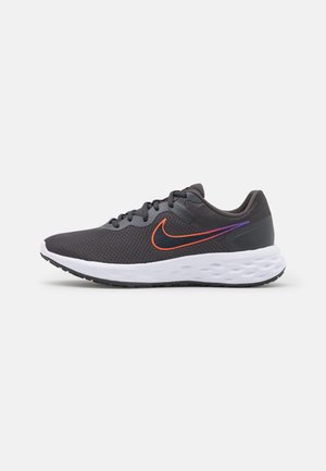 Dunkelgrauer Sportschuh mit schwarzen Schnürsenkeln, weißer, gepolsterter Sohle und orange-violettem Farbverlauf des Nike Swoosh Logos an der Seite.