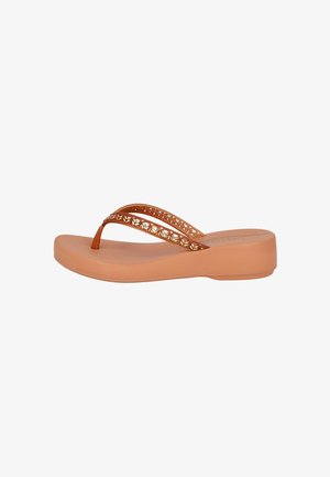 Sandalia de cuña color cuero con tiras de dedo perforadas y adornadas con detalles metálicos y suela acolchada.