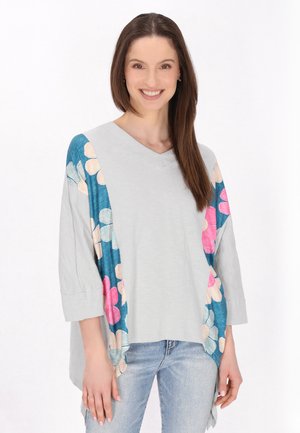Top grigio a scollo a V con maniche a tre quarti, caratterizzato da vivaci motivi floreali in rosa e blu sui lati. Tessuto dalla texture morbida.