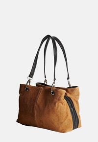 Bolso de ante marrón con asas de cuero negro, de forma rectangular suave y detalle de cremallera lateral para un fácil acceso.