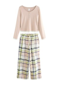 Light pink long-sleeve top with buttons paired with wide-leg plaid pants featuring green, navy, and pink stripes and an elastic waistband.