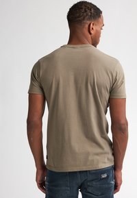 Olijfgroen katoenen T-shirt met korte mouwen, ronde hals en een gladde textuur, gezien van achteren. Minimalistisch ontwerp, zonder patronen.