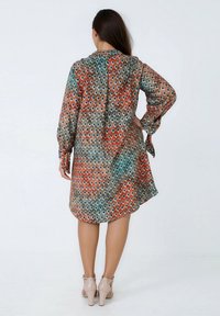 Langek mouw jurk in een lichtgewicht stof met een kleurrijk, abstract cirkelpatroon in oranje, teal en bruin. Ronde zoom.