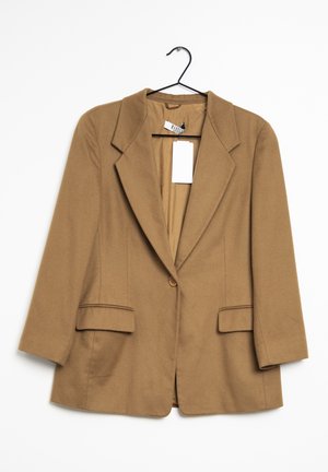 Bruine blazer met één knoop en revers, hangend aan een zwarte hanger, met twee voorflapzakken en een wit binnenlabel.