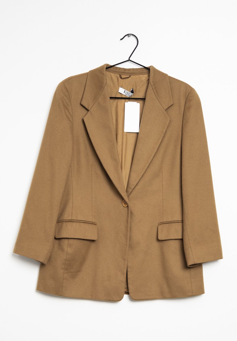 Blazer marron à un bouton avec revers, suspendu sur un cintre noir, avec deux poches avant à rabat et une étiquette blanche intérieure.