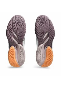 Suole delle scarpe in gomma grigia e viola con accenti arancioni. Presentano schemi testurizzati per una migliore aderenza e nodi circolari per la trazione.