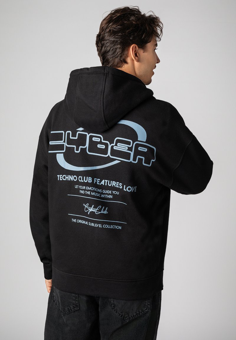 Black hoodie with a large blue graphic on the back, featuring text and logos. The fabric appears soft and has a relaxed fit.