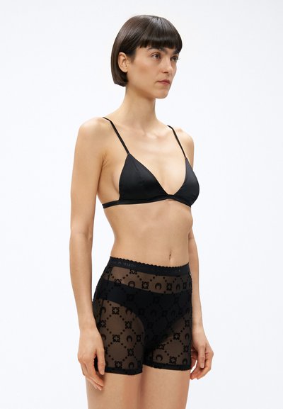 Černá souprava spodního prádla s trojúhelníkovou podprsenkou a krátkými kalhotami s vysokým pasem, vyrobená z průhledné síťoviny s květinovými vzory. Lemování s vlnitými okraji.