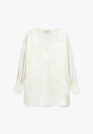 Hvid satinbluse med en dyb V-hals, lange pufærmer og en lige kant. Stoffet har en glat, blank overflade.