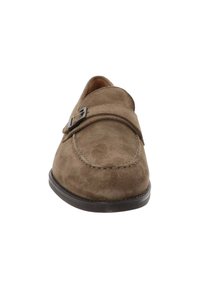 Chaussure slip-on en daim marron avec un bout arrondi, une sangle décorative et un détail de boucle en métal. Texture lisse et semelle en caoutchouc robuste.
