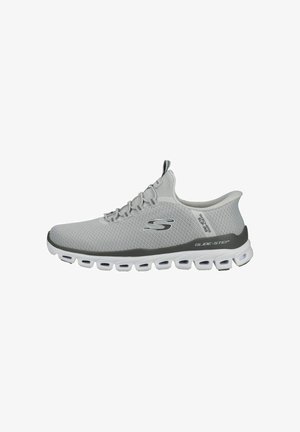 Zapatilla deportiva Skechers Glide-Step de color gris claro, con parte superior de malla transpirable, logo negro y suela blanca segmentada.