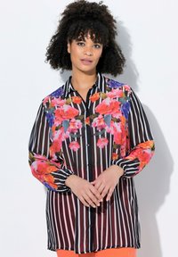 Camicia a maniche lunghe con motivo floreale, strisce verticali in bianco e nero e un tessuto leggero leggermente trasparente.