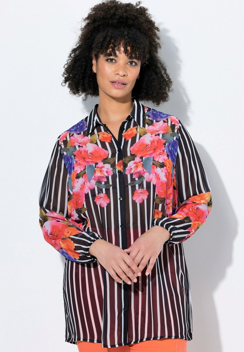 Camicia a maniche lunghe con motivo floreale, strisce verticali in bianco e nero e un tessuto leggero leggermente trasparente.