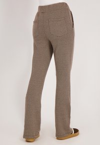 Bruine houndstooth-geprinte broek met een rechte pijp, zijzakken en een hoge tailleband, gemaakt van een zachte, geweven stof.