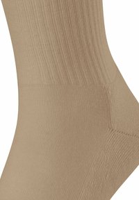 Calza a crew beige con texture a costine, materiale morbido, tallone e punta rinforzati. Progettata per il comfort con una vestibilità aderente attorno alla caviglia.