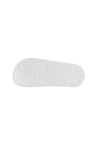 White rubber shoe sole with a textured star pattern and raised details, featuring a smooth edge and embossed logo at the center.
