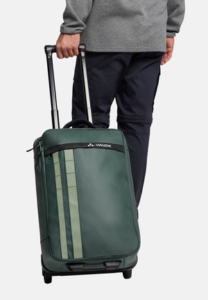 Groene koffer met wielen, voorzien van een textuur en duurzame buitenkant, met een zwarte handgreep en zijstrepen in een lichtere tint. Merklogo zichtbaar.