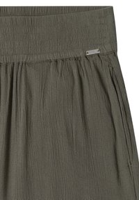 Jupe vert olive avec large ceinture élastique froncée et petite étiquette de marque en métal sur le côté droit près du haut.