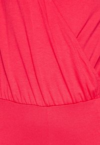 Raspberry pink garment with a soft texture, featuring a gathered bodice design and a smooth waistband. Wrinkled fabric adds dimension.