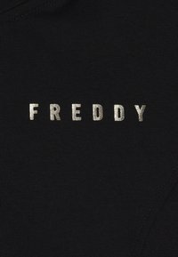 Tessuto nero con la parola "FREDDY" in lettere argentate metalliche. La superficie è liscia con una texture uniforme e senza motivi visibili.