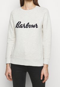 Krémová mikina z měkké látky, s černě vyšitým logem "Barbour", s žebrovanými manžetami a lemem.