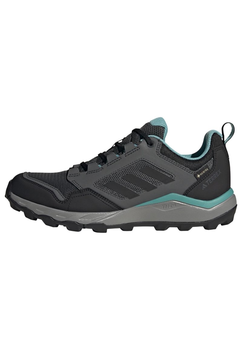 Zapatillas de trail running en negro y verde azulado, con una parte superior de malla, suela de goma duradera y acentos texturizados para mejorar el agarre.